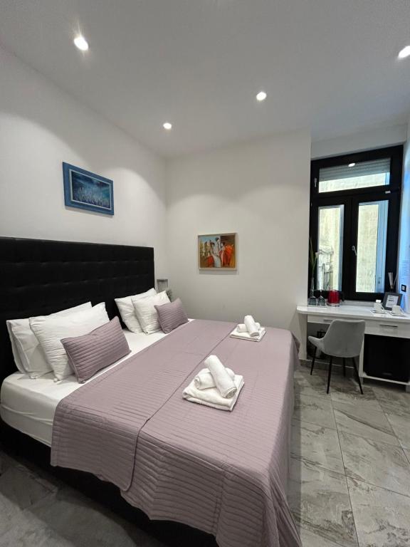 une chambre avec un grand lit avec deux serviettes dessus dans l'établissement Tango Rooms, à Split