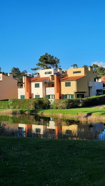 un gruppo di edifici riflettenti in un corpo idrico di Villa do Lago a Vibeira