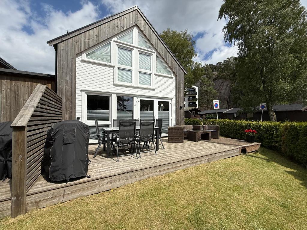 a wooden deck with a table and chairs on it at Sørlandet, nær stranden og Kristiansand dyrepark in Søgne