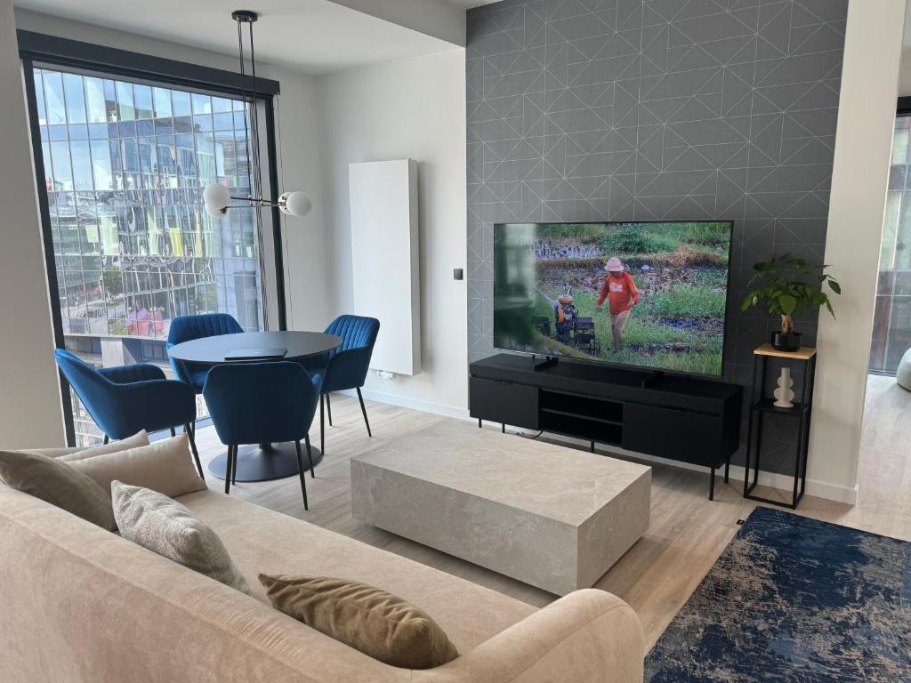 Una sala de estar con un sofá y un televisor de pantalla plana. en Concept JJ Luxury Apartments, en Varsovia