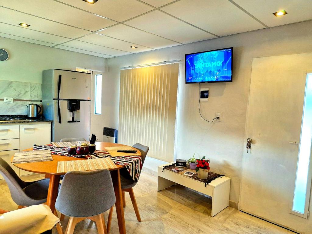 a living room with a table and a television on a wall at departamento familiar 2 in Malargüe