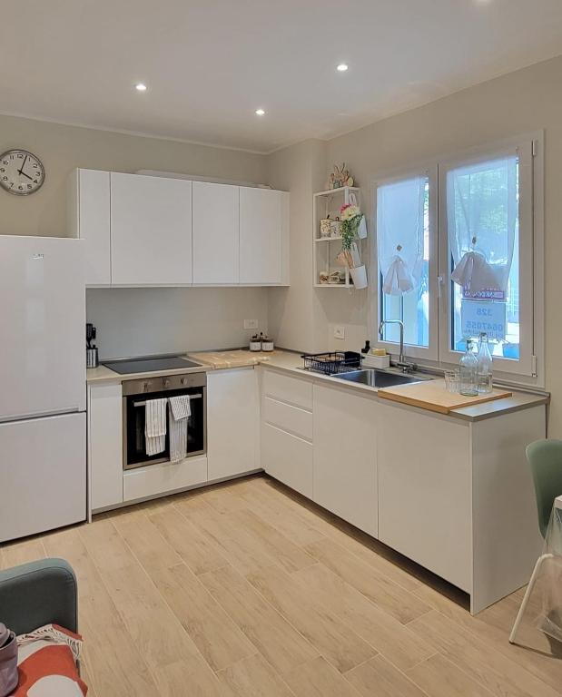 a kitchen with white cabinets and a sink at Pixel Sea Home a Misano Brasile 300 m dal mare e free parking, Misano World Circuit a 7 minuti di macchina in Misano Adriatico