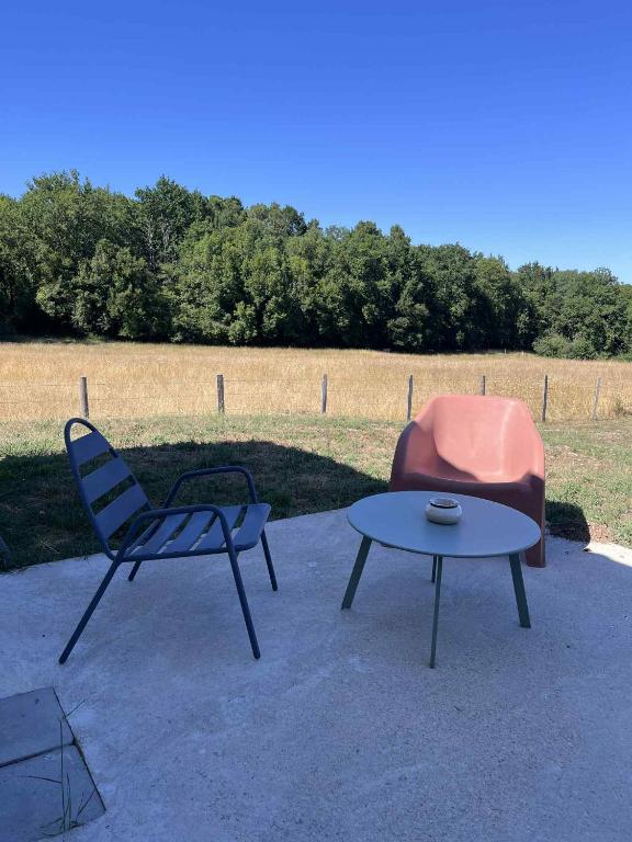 a chair and a table and a chair and a chair and a table at Maison au calme in Douzillac