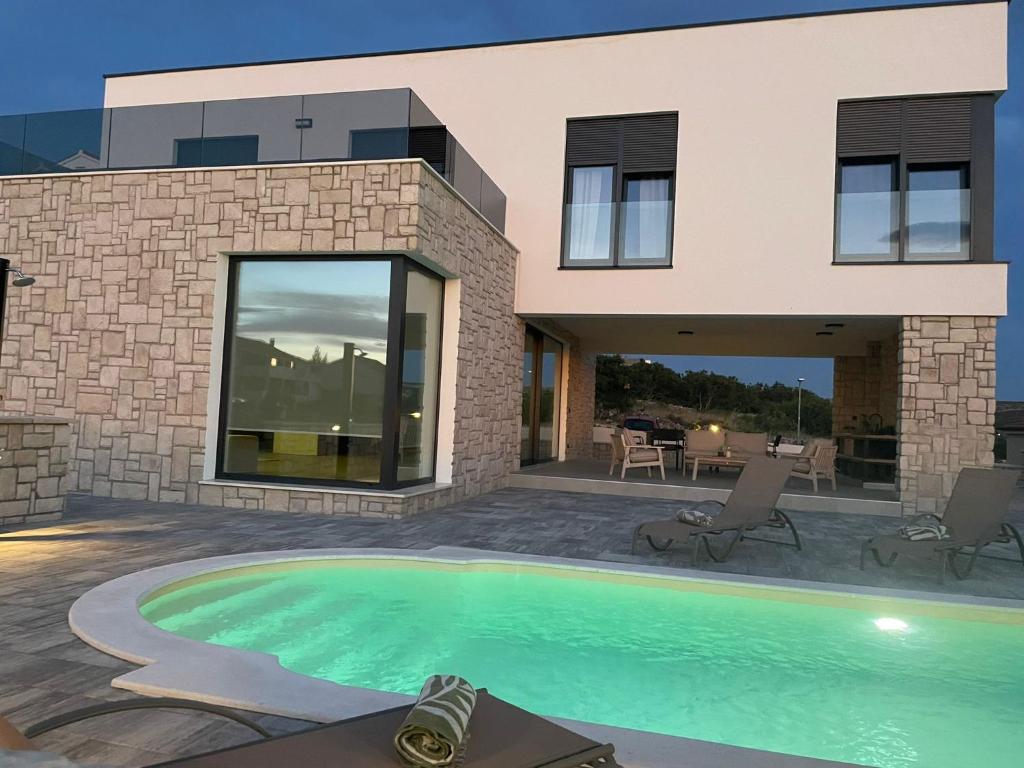 a house with a swimming pool in front of a house at Villa Gligora in Kolan