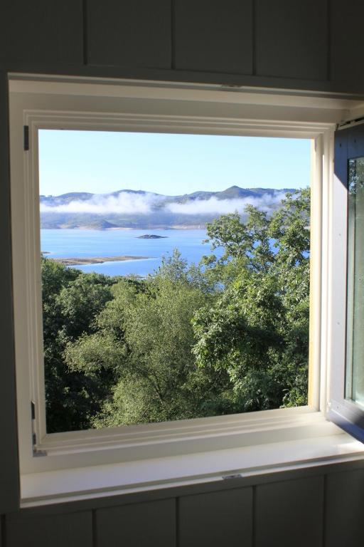 ein Fenster in einem Zimmer mit Blick auf das Wasser in der Unterkunft Moinhos da Corga in Antigo