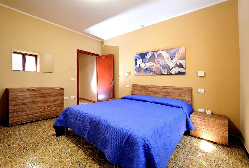 a bedroom with a bed with a blue blanket at Domus Santa Maria in Narni