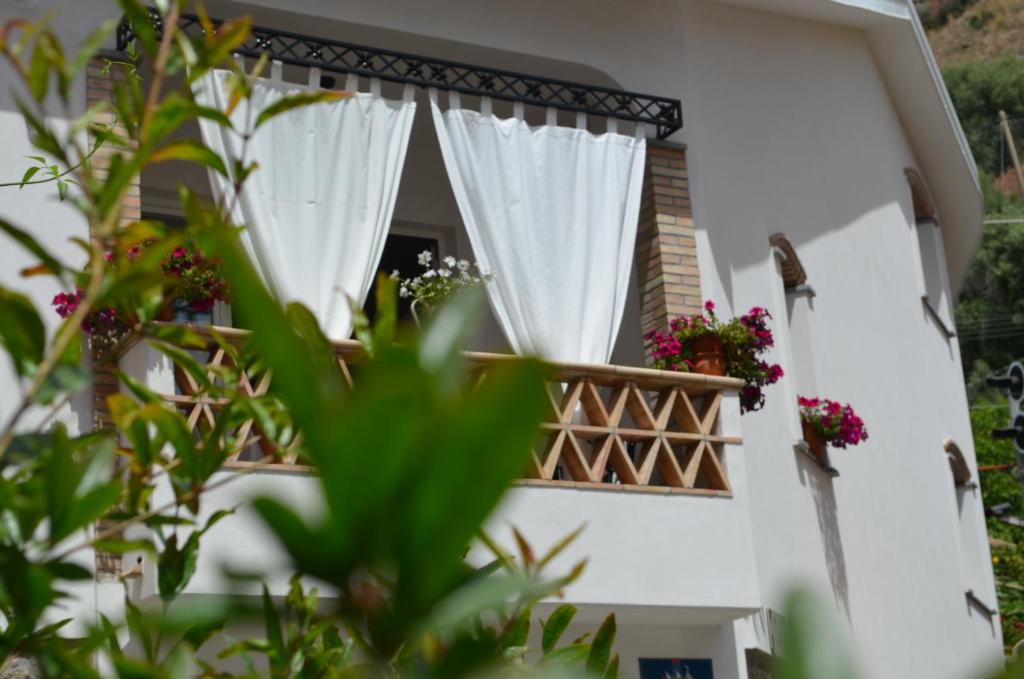 een wit huis met een raam met bloemen erop bij Invito al viaggio in Giardini Naxos