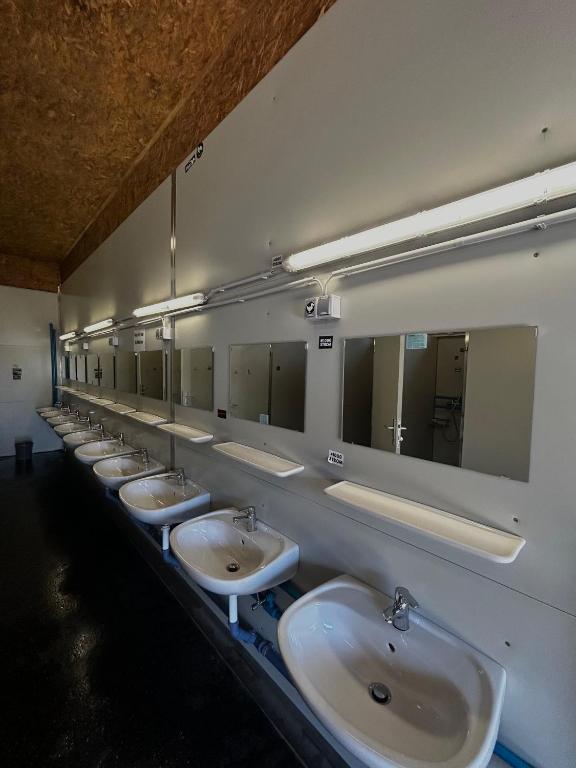 una fila di lavandini in un bagno pubblico con specchi di Tinyhome Spielberg -Container Lodge a Flatschach