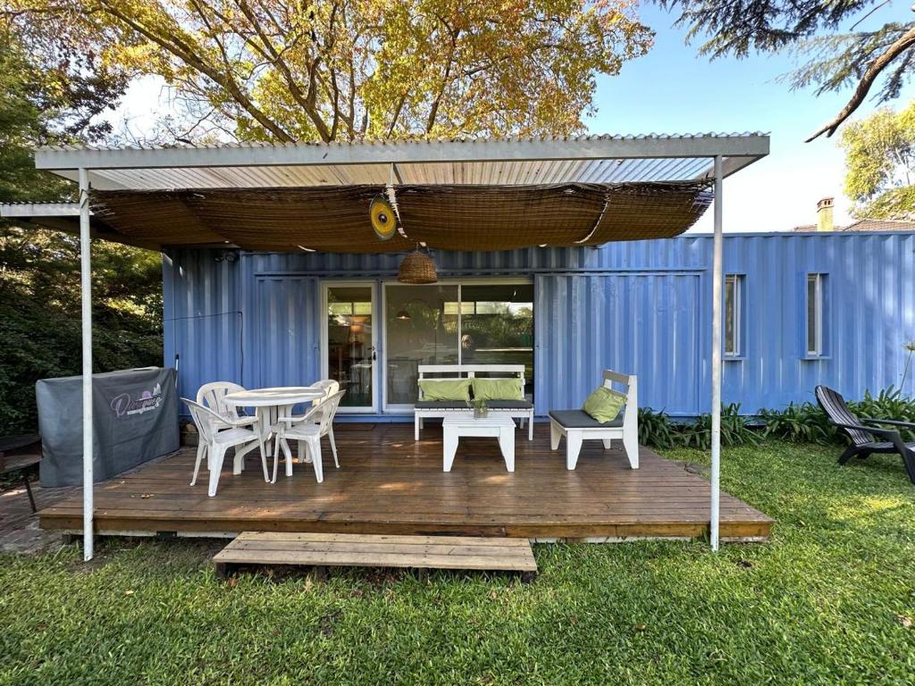 a deck with a table and chairs on a house at Diva gues del Pereyra Sur in Villa Elisa