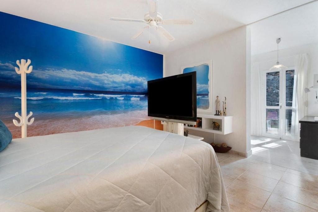 a bedroom with a large bed with a flat screen tv at pardelo in Adeje