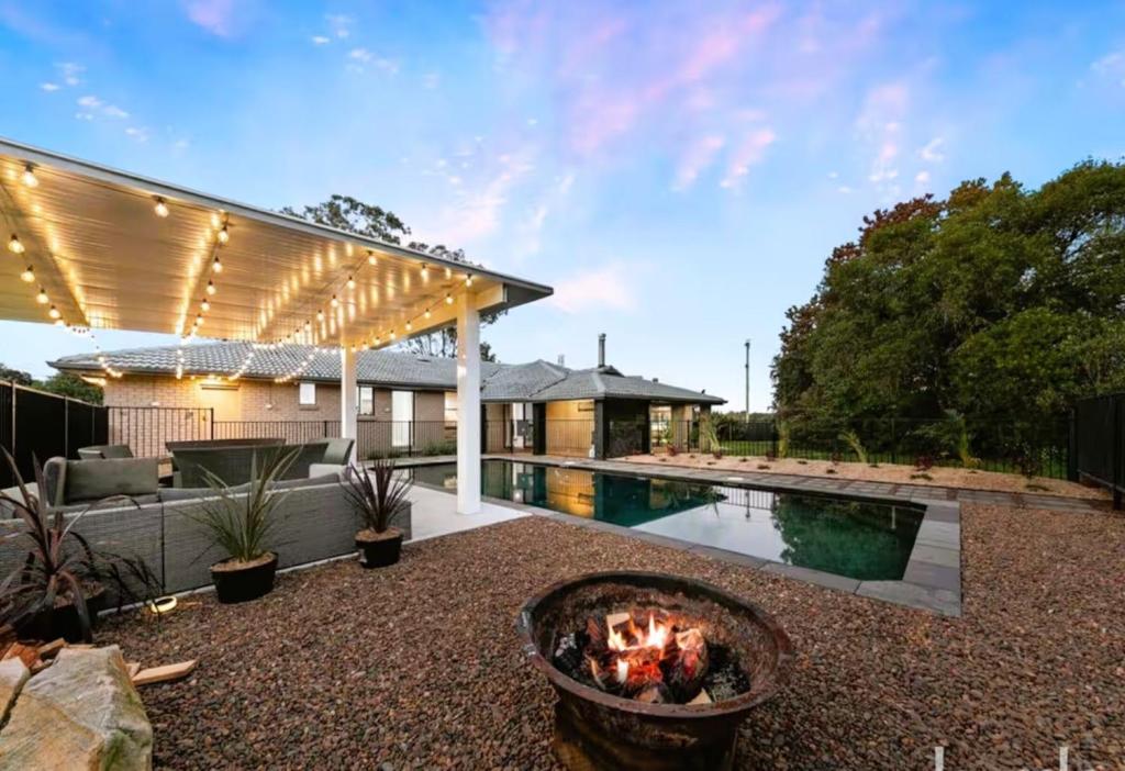 un patio trasero con una hoguera y una piscina en Wine Stop Quarters Pool, Tour, Pickup Wineries, en Nulkaba