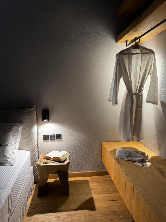 a bedroom with a bed and a robe hanging on the wall at EJ Boutique Suites in Milina