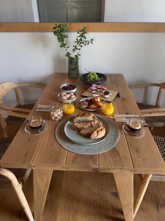a wooden table with a plate of food on it at EJ Boutique Suites in Milina