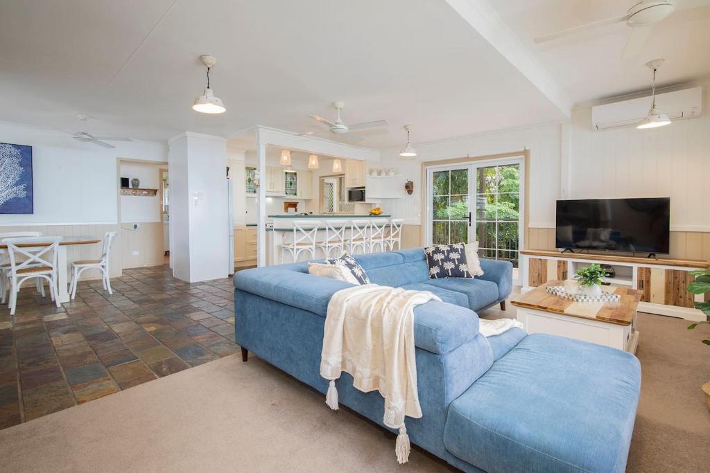 un soggiorno con un divano blu e una cucina di The Lake House - Waterfront Haven with Granny Flat a Karraganbah