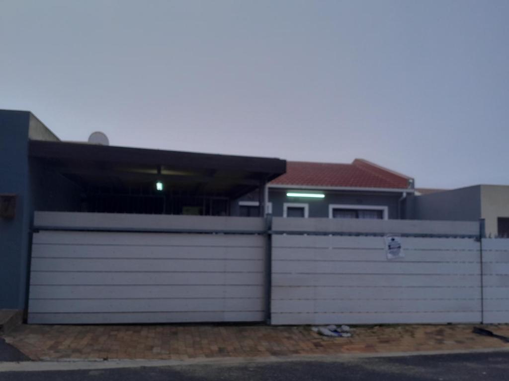 a house with two garage gates in front of it at GLOBALNEST guest house in Cape Town
