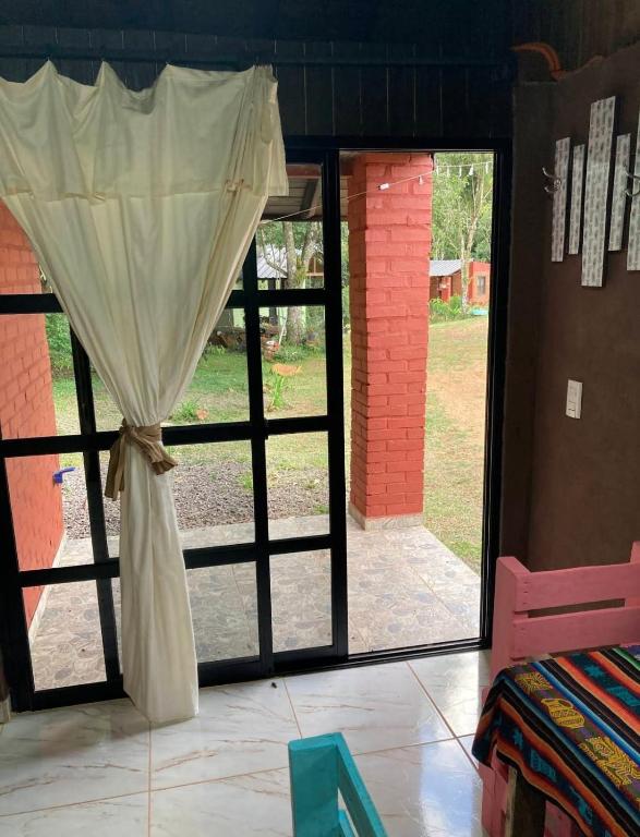 a window with a curtain in a room at El Pueblito Lodge in El Soberbio