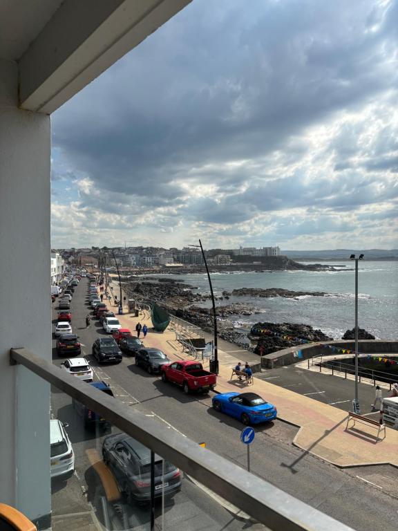 a view of a street with cars parked on the beach at Prime Port Apartment in Portstewart