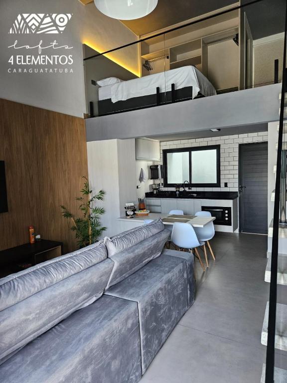 a living room with a couch and a loft bed at Lofts 4 Elementos - Ar - Martim de Sá - Caraguatatuba in Caraguatatuba