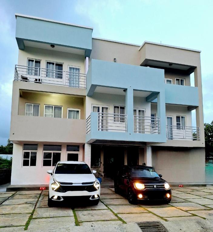 two cars parked in front of a building at Ocean Mist Suites in Arnos Vale