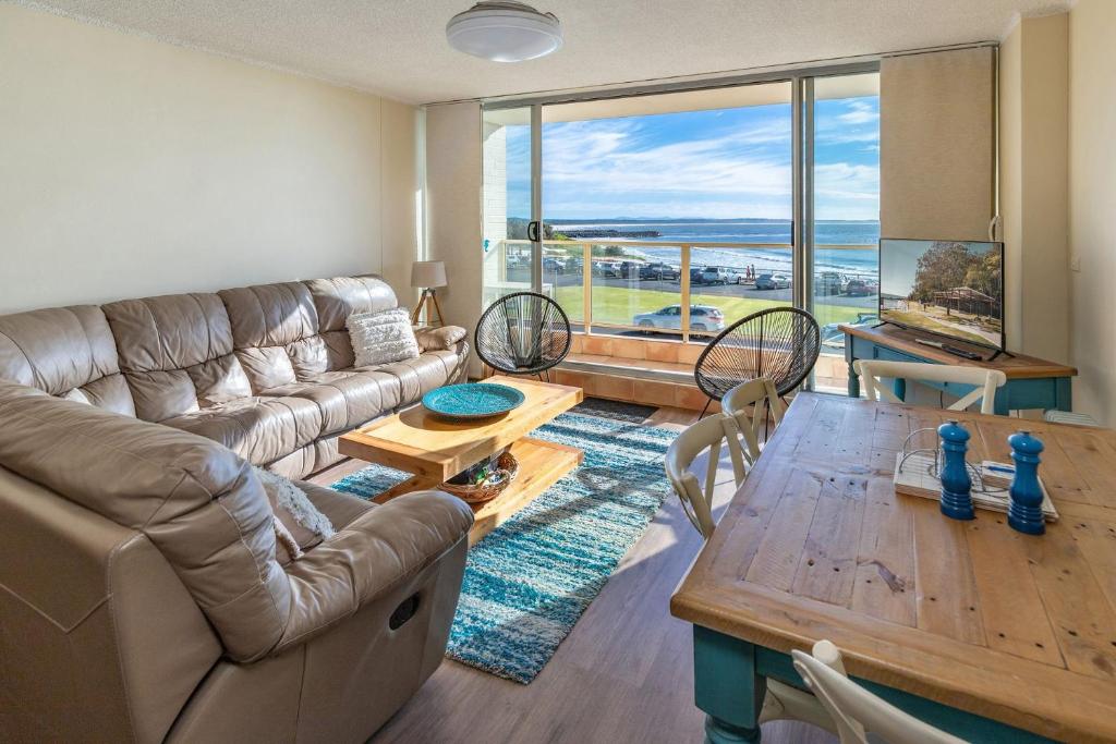 una sala de estar con un sofá y una mesa en Ebbtide 8, en Forster