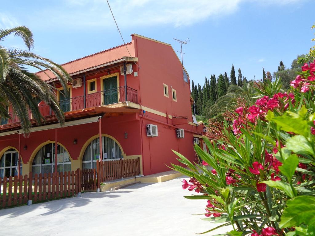 a red building with flowers in front of it at Skyline in Velonádes