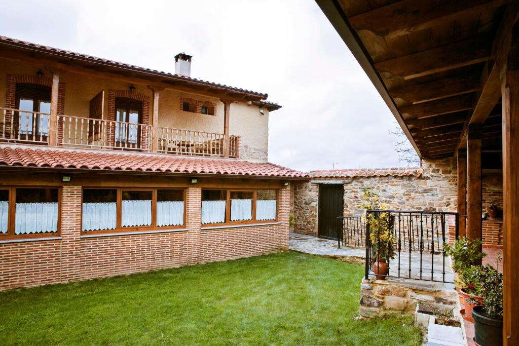 una vista exterior de una casa con patio en Hotel Rural El Habanero, en Destriana