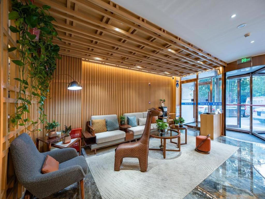 ein Wohnzimmer mit einer Couch und einem Tisch und Stühlen in der Unterkunft Super 8 Hotel Premier Beijing Changping Science & Technology Park in Ch'ang-p'ing-hsien