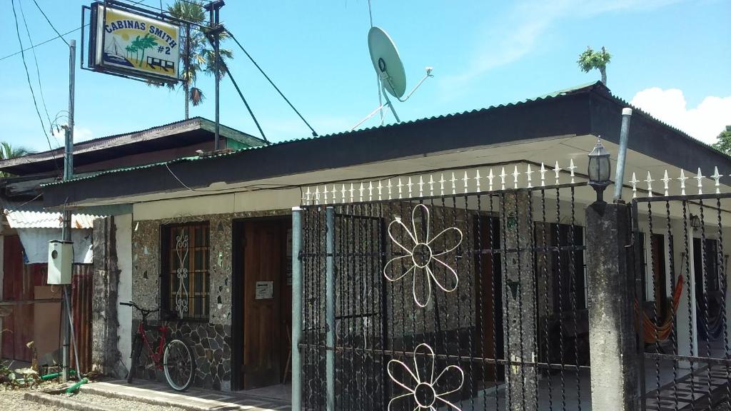 un edificio con una valla con una flor pintada en él en Cabinas Smith 2 en Cahuita