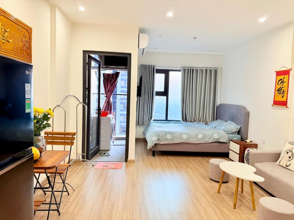 a living room with a couch and a bed at Vinhome Smart City Apartment-Studio Sakura Luxury in Phú Thú