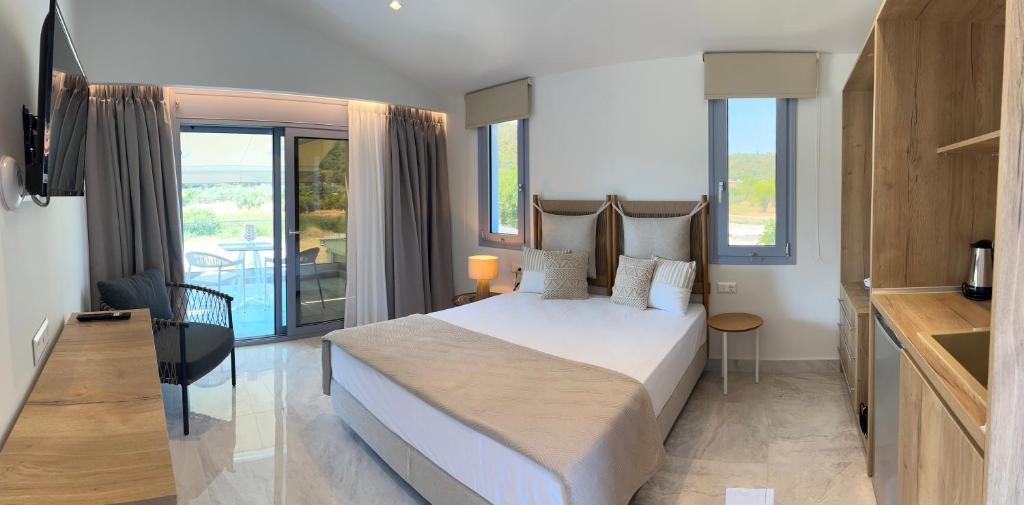 a bedroom with a large bed and a balcony at Notia Luxury Living in Porto Koufo