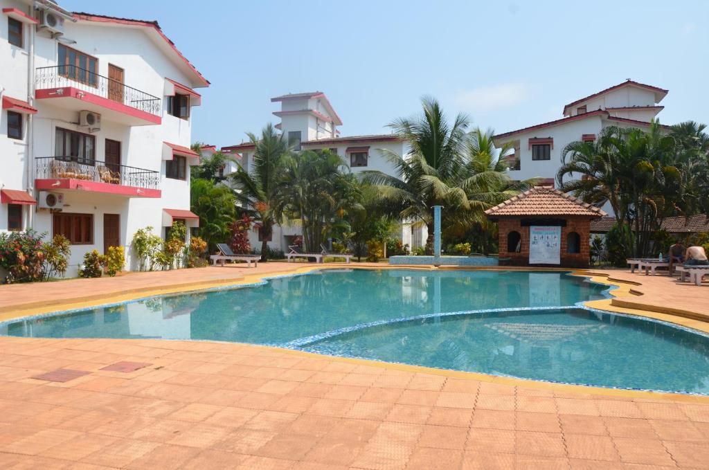 a swimming pool in front of a building at BBN Serviced Apartment in Calangute