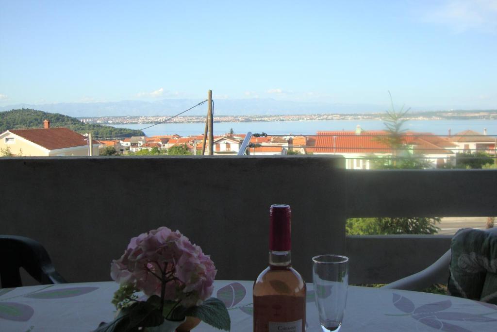 a bottle of wine sitting on a table with a glass at Apartments Jadro in Kali