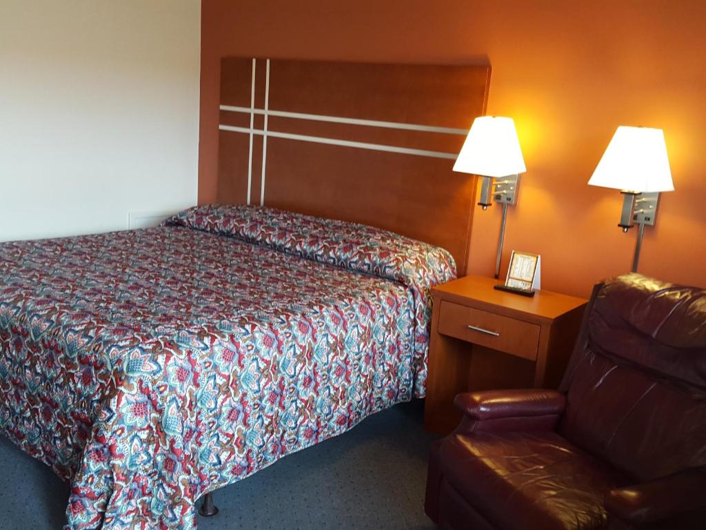 ein Hotelzimmer mit einem Bett und einem Stuhl in der Unterkunft Travelers Lodge Marshall in Marshall