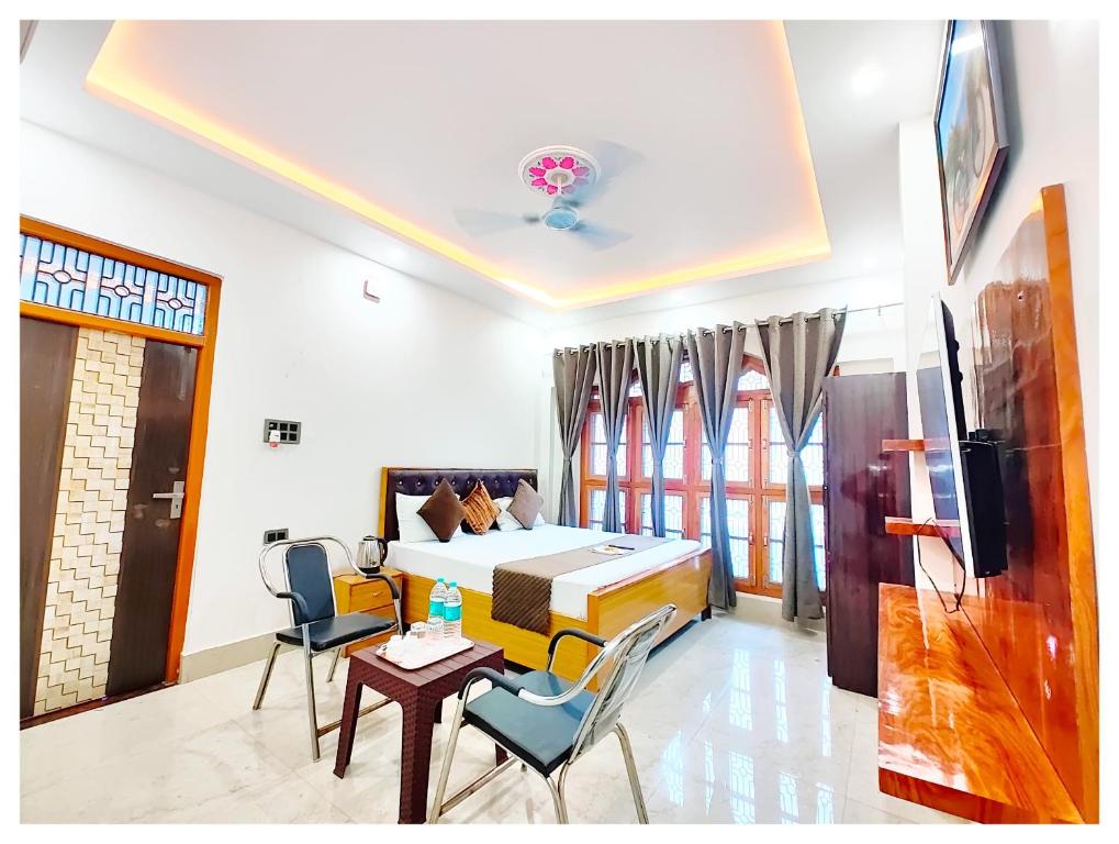 AyodhyaHOTEL SHREE MATESHWARI # PALACE Near Ramjanambhoomi - Shri Hanuman Garhi Mandir 800M & Ayodhya Dham Junction Railway Station - Fully Air Conditioning Rooms - Free Wifi & Parking Facilities - Excellent Customer Service的一间带床、桌椅的酒店房间