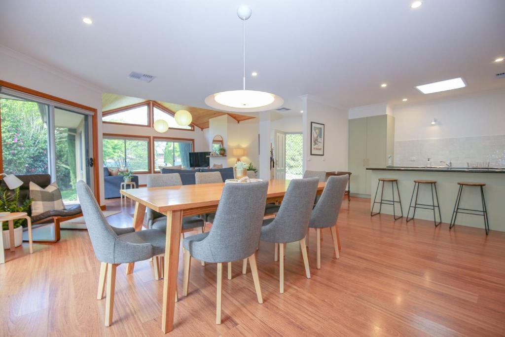 a dining room and living room with a table and chairs at On The Trail in Bright
