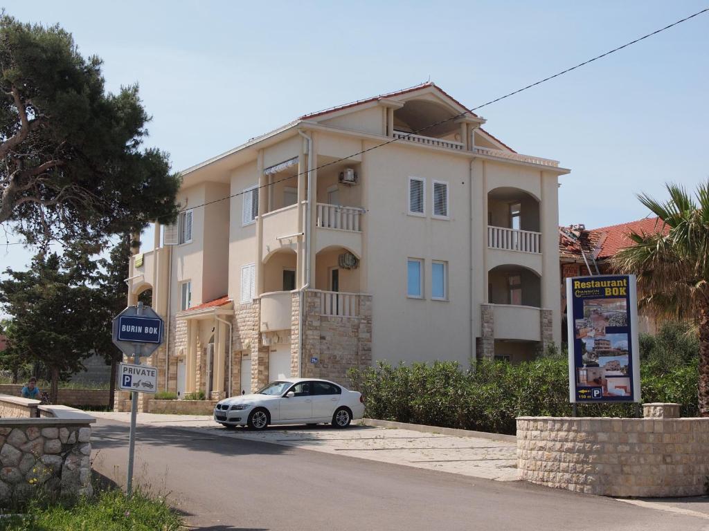 a white car parked in front of a large building at Apartment Tena in Novalja