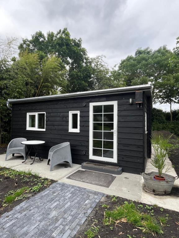 a black tiny house with a table and chairs at Zwart Pareltje in Kiel