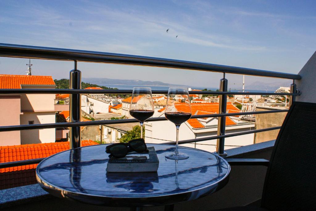 una mesa con 2 copas de vino en el balcón en Apartment Ivana, en Makarska