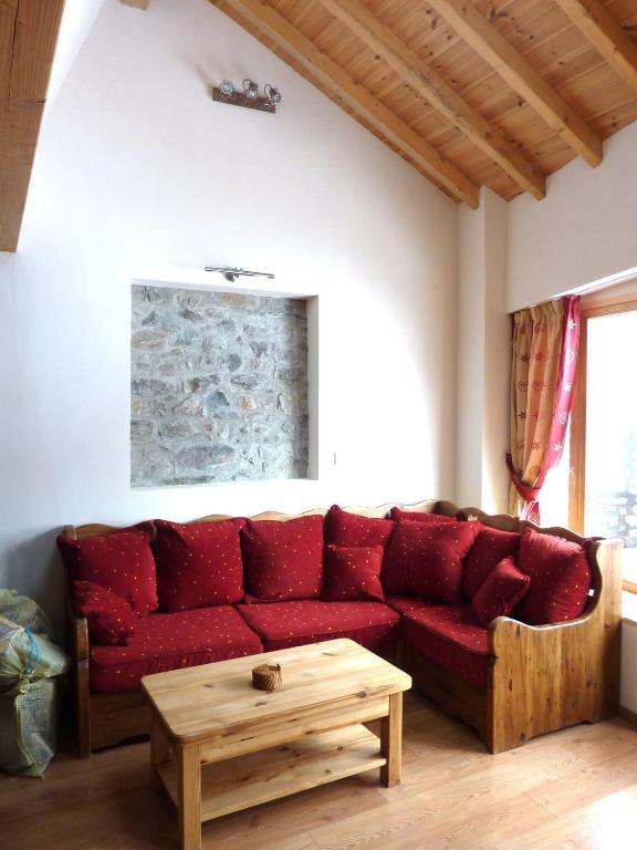 un salon avec un canapé rouge et une table dans l'établissement Les Cabasses 8 - Housing in a village house, à Villar-dʼArêne