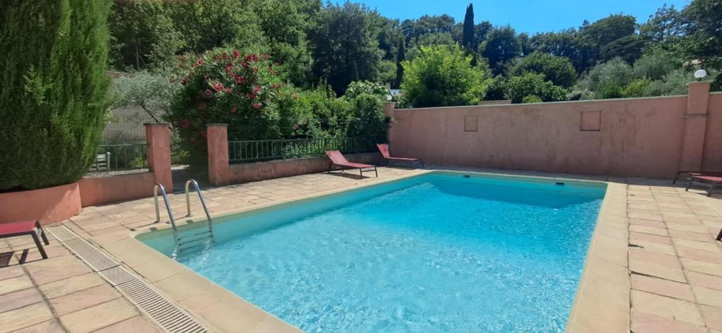 a swimming pool with two chairs in a yard at Les Verveines de Vaison in Vaison-la-Romaine