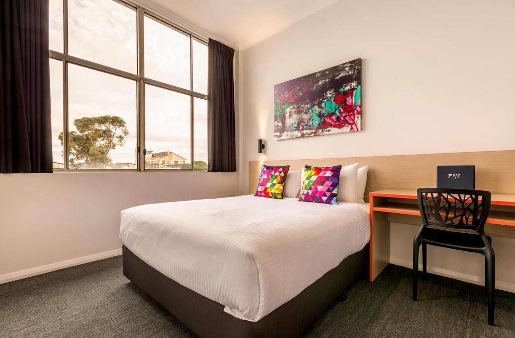 a hotel room with a bed and a desk at Nightcap at Ashley Hotel in Braybrook