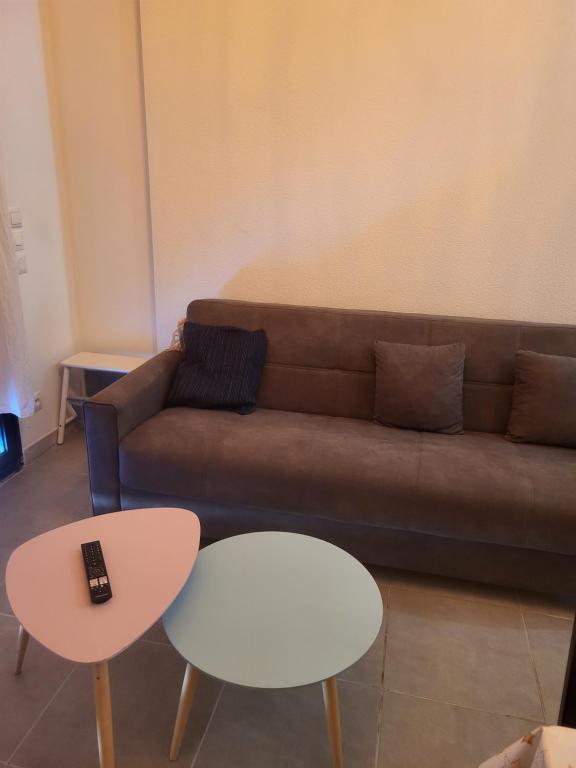 a living room with a couch and two tables at Joli nid douillet in Les Sorinières