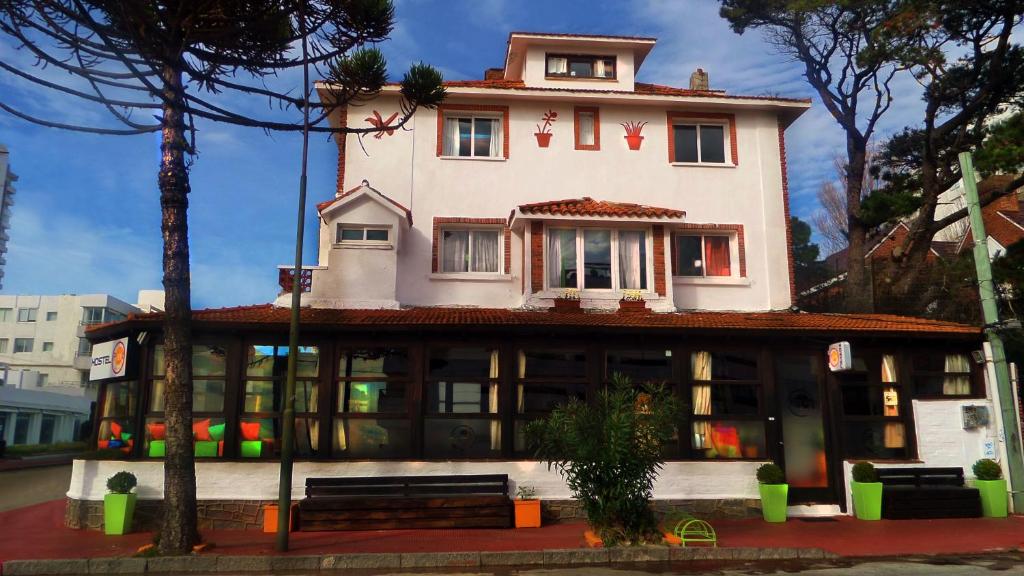 een hoog gebouw met een huis erop bij Planet Punta del Este Hostel in Punta del Este