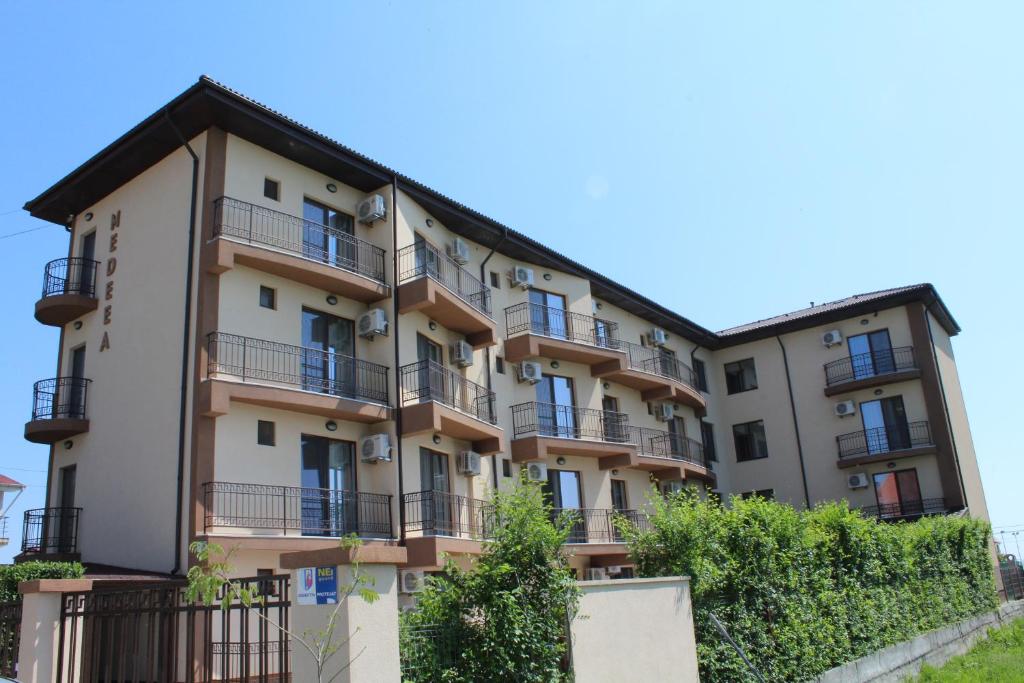 科斯蒂內甚蒂的住宿－Vila Medeea，公寓大楼设有阳台和树木