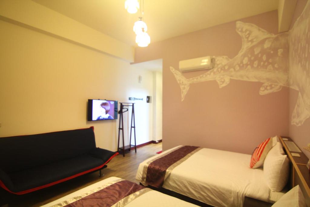 a hotel room with two beds and a tv at Blue Bay in Green Island