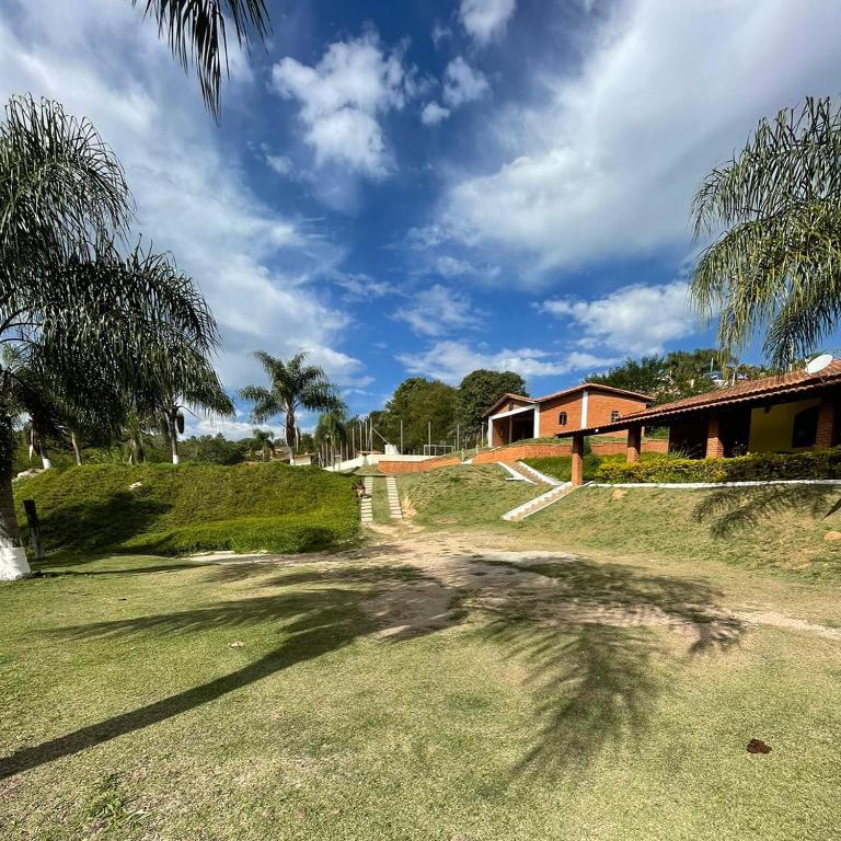 a palm tree in a yard with a house at Chácara Curuco in Mairinque