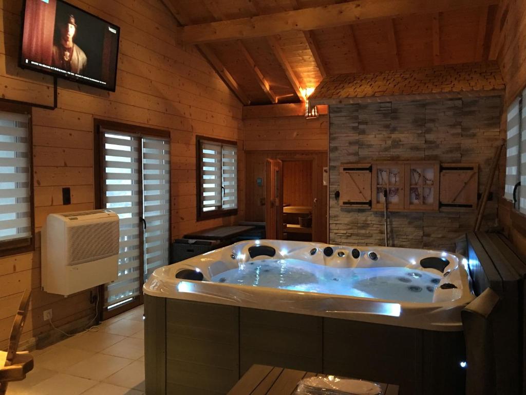 a jacuzzi tub in a room with wooden walls at Chalet de la Roche Gauthier in Gérardmer