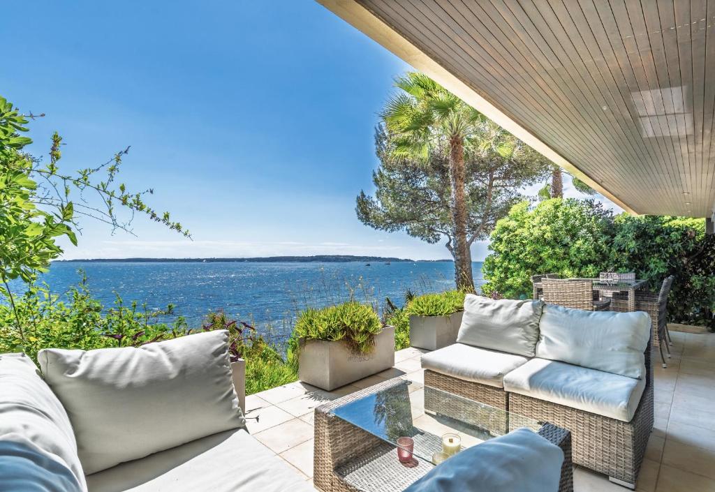 d'une terrasse avec des canapés et une vue sur l'eau. dans l'établissement ADRIANA by Terry's Homes WATERFRONT SEAVIEW BEACH, à Cannes