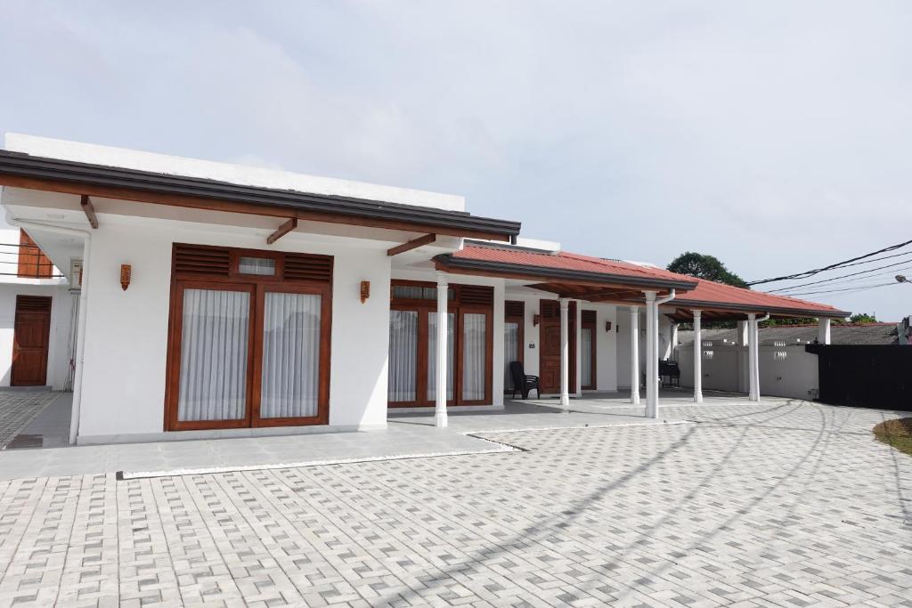 a white house with a courtyard in front of it at AirBlue Villa in Ratmalana