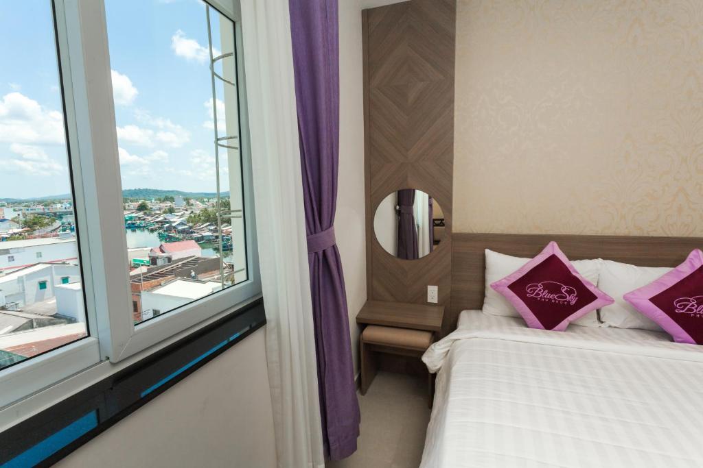 1 dormitorio con 2 camas y ventana grande en Blue Sky Phu Quoc Hotel en Phu Quoc